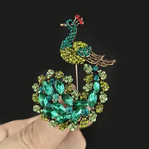 Detail shot of vintage peacock brooch with green rhinestones and crystal emerald feathers