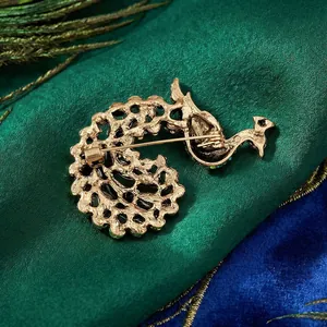 Back view of vintage gold peacock brooch with intricate hollow metalwork and pin closure
