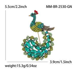 Luxurious peacock brooch with green crystals and gold finish on white background