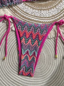 Detail of crochet bikini bottom with multi-colored waves and pink side ties