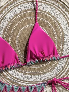 Macro view of hot pink bikini top with handmade braided straps and colorful knit trim