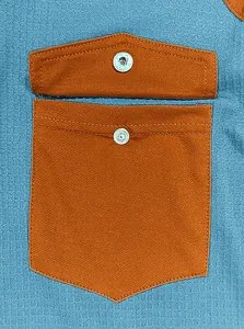Detailed close-up of hooded sweatshirt pocket with metal button and blue fabric texture