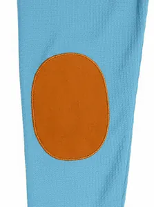 Detailed close-up of blue waffle knit fabric with a brown faux suede elbow patch
