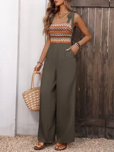 Detail of army green jumpsuit with geometric printed bodice and tie-up straps