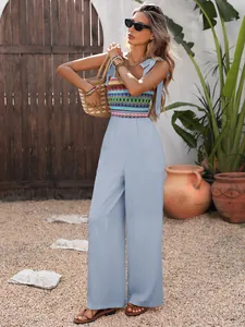 Detail of bohemian wide-leg jumpsuit with colorful ethnic embroidery and tie-up straps
