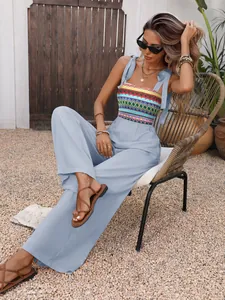 Detail of colorful bohemian embroidery and tie-up straps on light blue jumpsuit