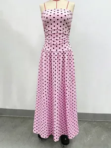 Detail of the pink polka dot maxi dress featuring a cinched waist and pleated A-line skirt