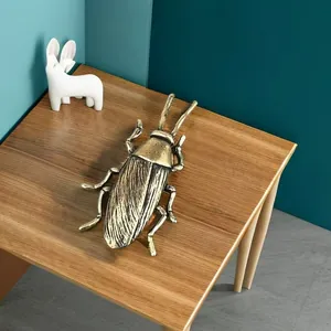 Detalle macro de las alas de langosta en latón envejecido sobre mesa de madera