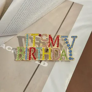 Détail de la broche IT'S MY BIRTHDAY avec cristaux colorés sur base en métal doré