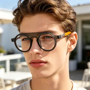 Close-up of stylish round black frame sunglasses with orange temples on male model