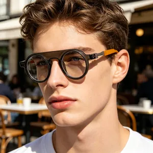 Detail of round sunglasses with translucent frames and orange temple accents on a male model