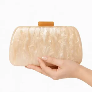 Détail d'une pochette de soirée en acrylique marbré beige avec fermoir ambré