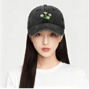 Close-up of small white daisy flower embroidery on washed cotton baseball cap texture