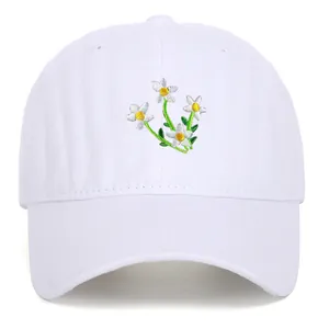 Detailed view of exquisite floral embroidery on a premium white cotton baseball cap