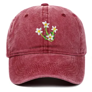 Close-up of floral embroidery on washed vintage dark red cotton baseball cap