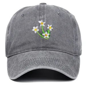 Detailed close-up of white flower embroidery on dark grey washed cotton baseball cap