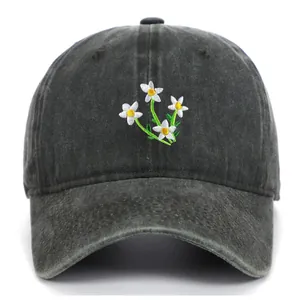 Detail of white daisy embroidery on dark grey washed cotton baseball cap for women