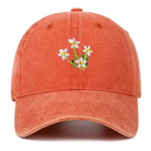 Close-up of white flower embroidery and washed cotton texture on vintage orange cap