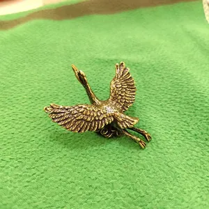 Detailed macro of solid brass crane figurine with vintage texture and wings spread