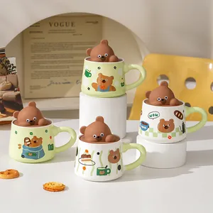 Detail of cute bear ceramic mugs with 3D bear lids in light green and cream white