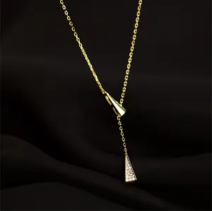 Macro shot of gold Y-shaped necklace with polished and pavé diamond triangle pendants
