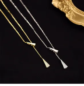 Macro shot of gold and silver geometric triangle pendants with sparkling zircon details