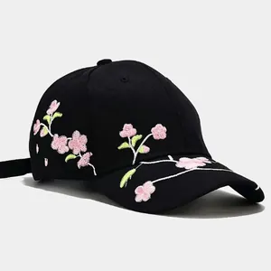 Black cotton baseball cap featuring detailed pink peach blossom floral embroidery