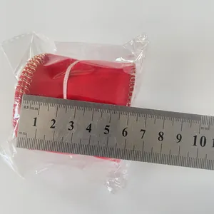 6.3cm red velvet Christmas ribbon with gold edges being measured with a metal ruler