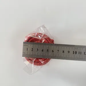 Top view of a 6cm red and gold festive decorative ribbon roll with measurement ruler