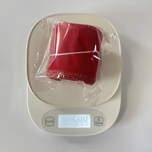 Weight measurement of 6cm red velvet Christmas ribbon with gold edges on scale