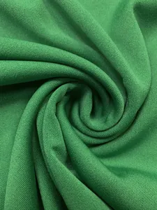 Macro shot of bright green honeycomb piqué fabric texture and spiral draping detail