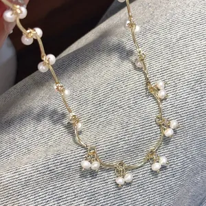 Detail of freshwater pearl necklace with gold wavy chain and dangling pearl clusters