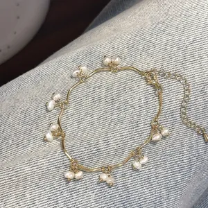Detailed view of wave-shaped gold pearl necklace on denim background texture