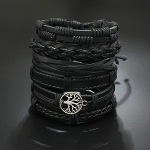Detail of multi-layer men's black leather bracelets featuring a Tree of Life charm