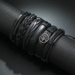 Detailed close-up of multi-layer black leather bracelets with tree of life metal charm