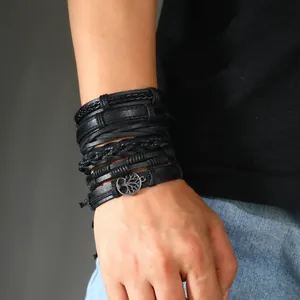 Close-up of men's layered black leather bracelet set featuring Tree of Life charm