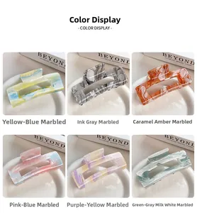Detail view of six acrylic claw clips with marble ink patterns in grid layout
