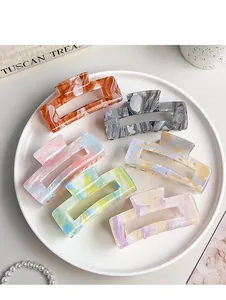 Set of six large acrylic hair claws with marble ink texture in a white tray