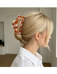 Detail of a large rectangular marble pattern hair claw clip on a woman's hair