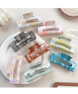 Flat lay of eight colorful marble patterned rectangle hair claws in various ink shades
