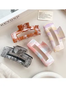 Macro shot of large hollow square hair claws with elegant acrylic marble textures