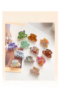 Flat lay of small acetate hair claw clips in various floral and marble patterns