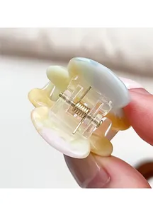 Detailed macro view of small acetate flower hair claw in pastel macaron tones