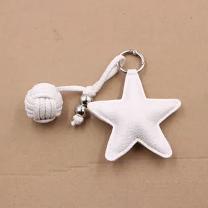 Close-up of white leather star charm with woven cord and silver bead details