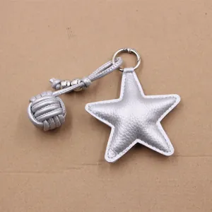 Detail of silver star leather keychain with braided rope and metal ring accessory