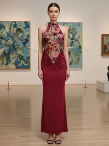 Elegant burgundy halter neck evening gown with sequin floral embroidery and ruched detail