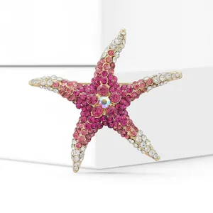 Macro view of starfish brooch with pink gradient rhinestones on golden metal base