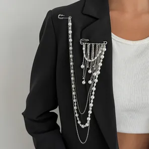 Detail of layered silver tassel chain brooch with white pearls on a black suit jacket