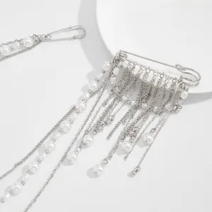 Close-up of silver tassel brooch pins featuring white pearls and layered chains for suits