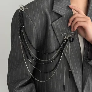 Detail of punk tassel epaulette brooch with multi-layer metal chains on a suit